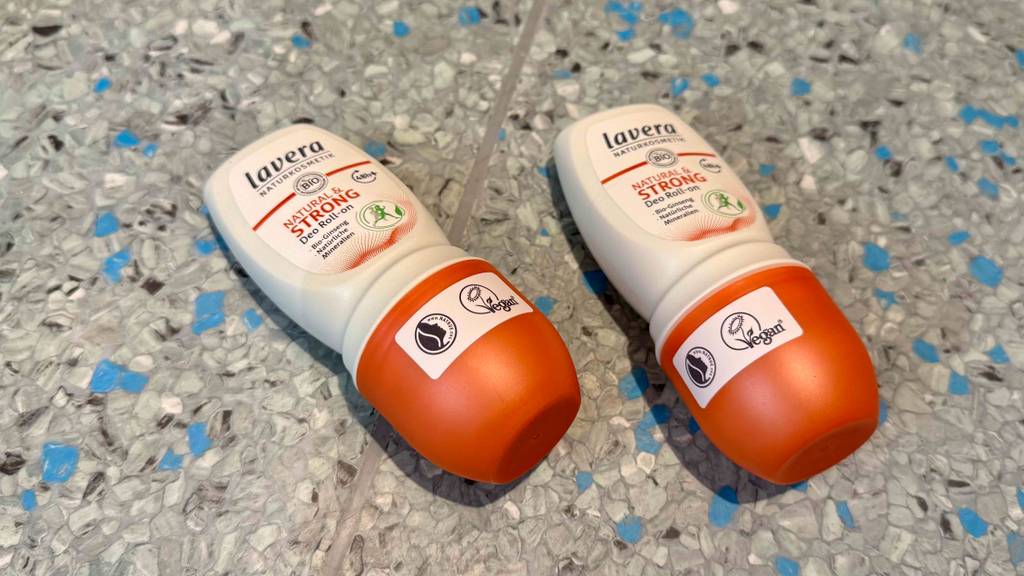 Lavera-Deo-Test: Zwei Deoroller liegen auf einem gesprenkelten Boden.