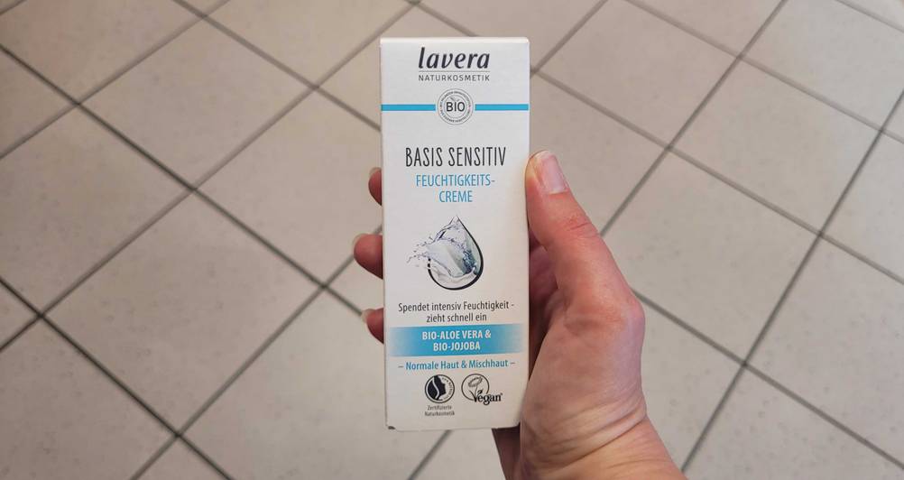 Eine Hand hält eine Packung der getesteten Lavera-Gesichtscreme hoch.