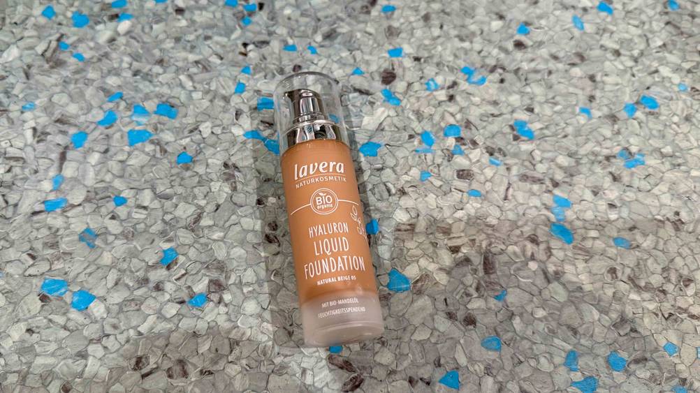 Das getestete Lavera-Make-up auf einem grauen Boden liegend.