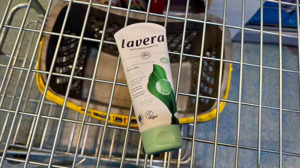 Im Test: Eine Tube Naturkosmetik-Bodylotion liegt in einem Einkaufswagen.