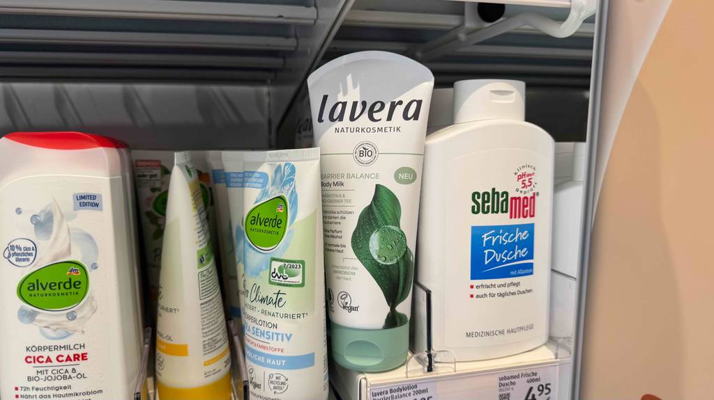 Eine Tube getestete Naturkosmetik-Bodylotion steht zwischen anderen Produkten.