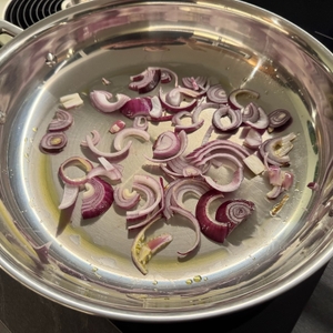 Zwiebeln in der Le Creuset 96200228001100 werden angebraten