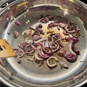 Leicht gebratene Zwiebeln in der Le Creuset 96200228001100 mit einem Holzspatel