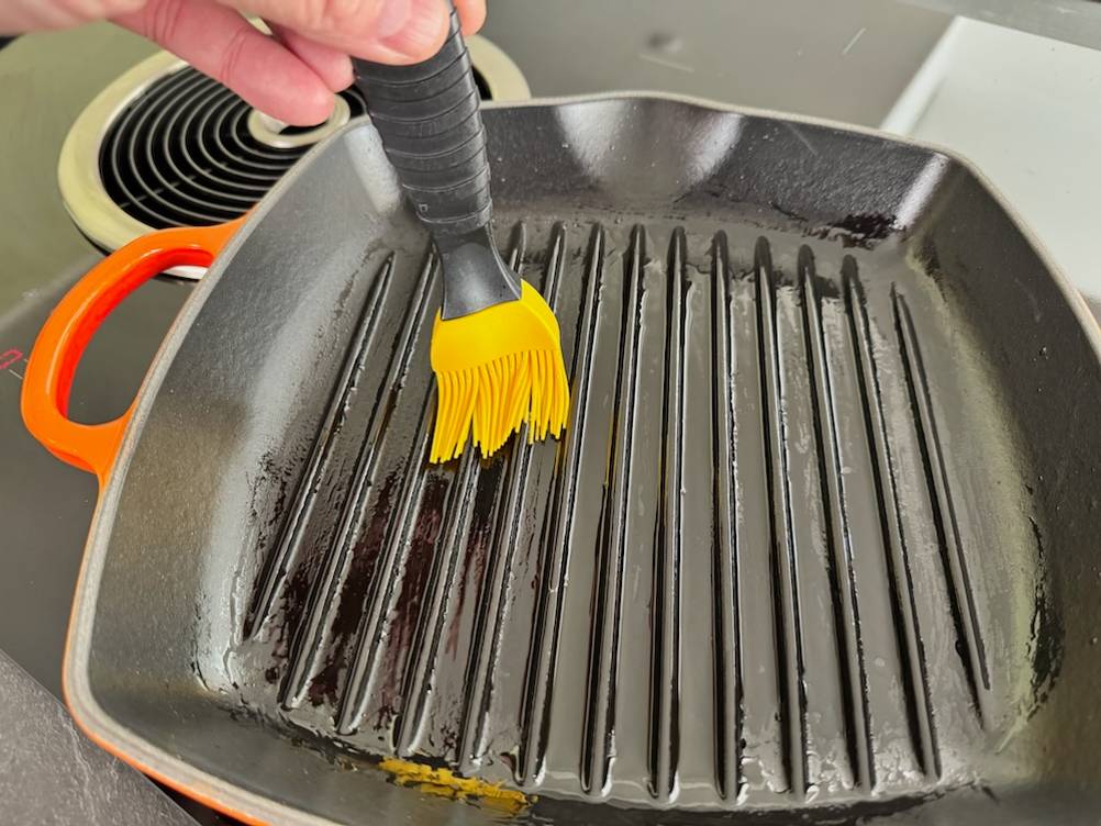 Le-Creuset-Grillpfanne Signature wird mit einem Pinsel eingeölt