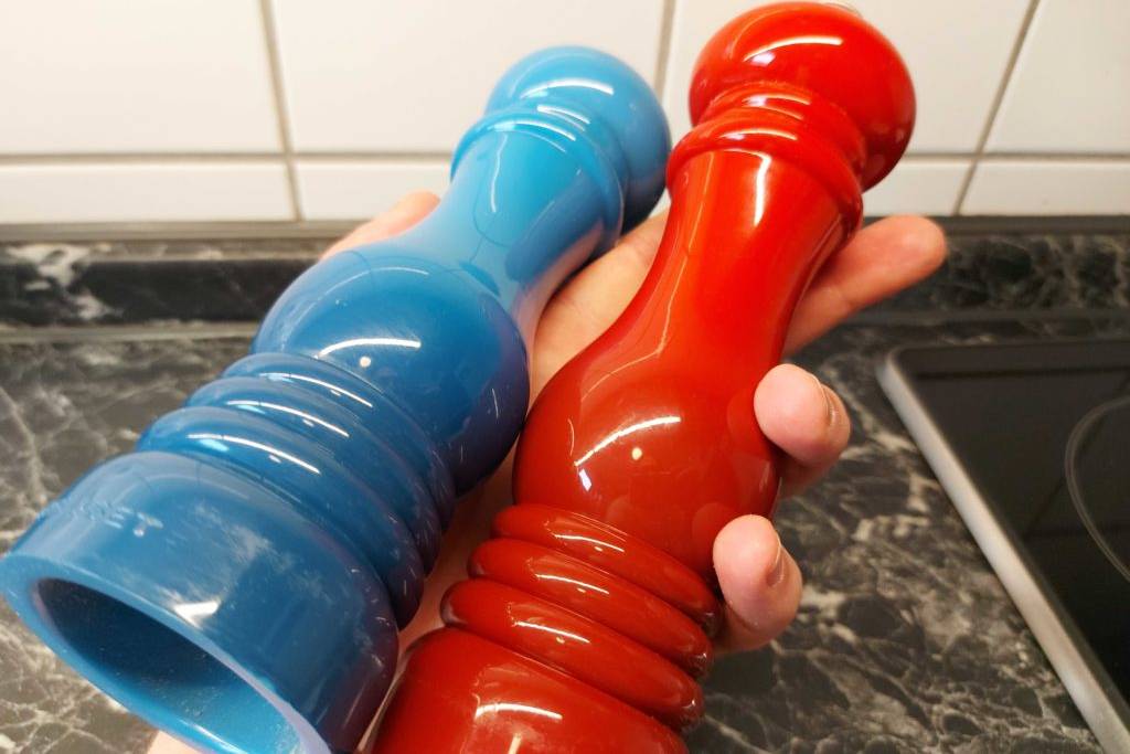 Mensch hält eine Salz- und eine Pfeffermühle zum testen in der Hand.