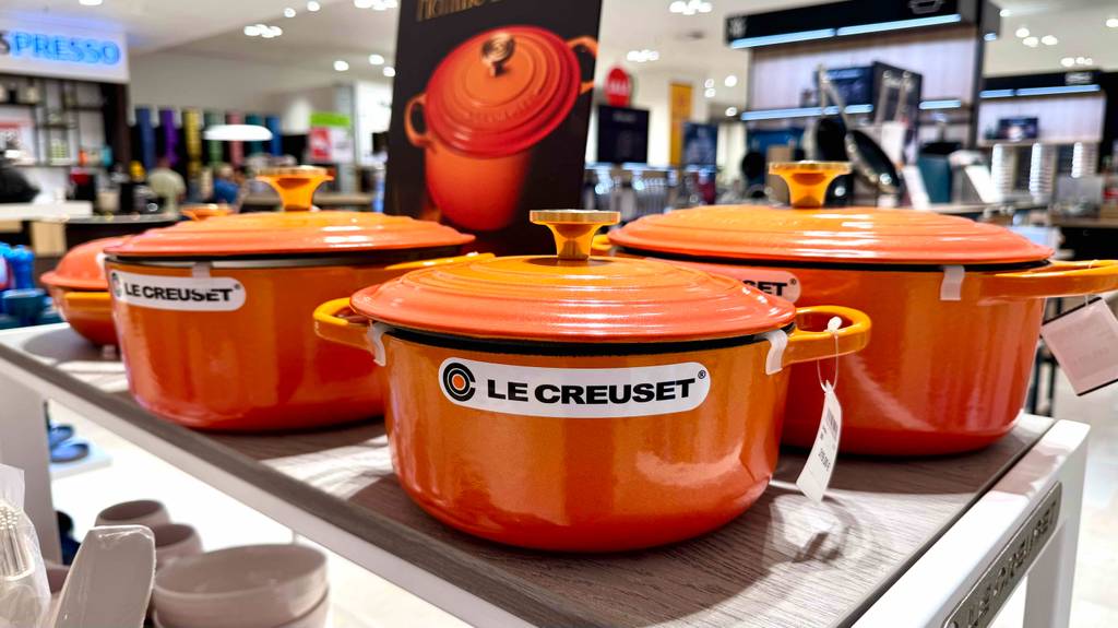 Le-Creuset-Töpfe im Test: Mehrere Töpfe stehen nebeneinander auf einem Regal.