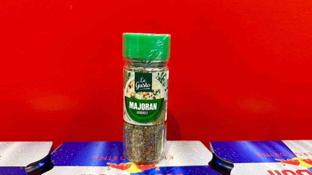 Getesteter Majoran in der Gewürzdose befindet sich vor einem roten Hintergrund auf Red Bull Dosen.