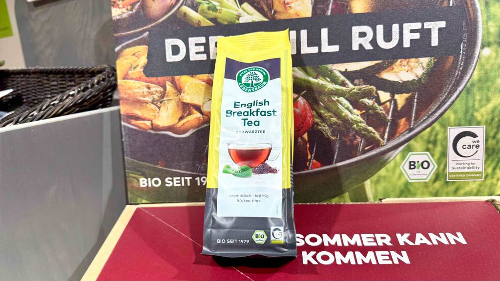 Eine Packung Lebensbaum-Tee steht zum testen vor einem Bio-Plakat.