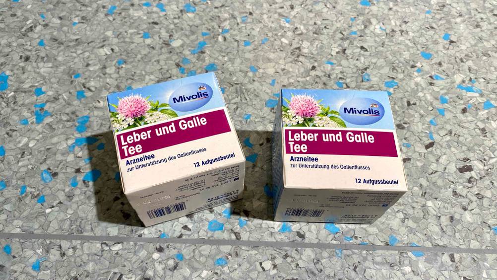 Lebertee getestet: Zwei Packungen nebeneinander auf einem grauen Boden liegend.