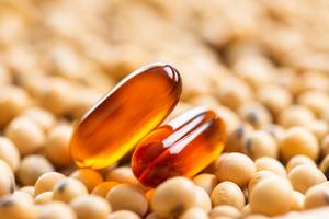 Lecithin-Kapseln-Test: Auf Sojabohnen liegen zwei Lecithin-Kapseln. 
