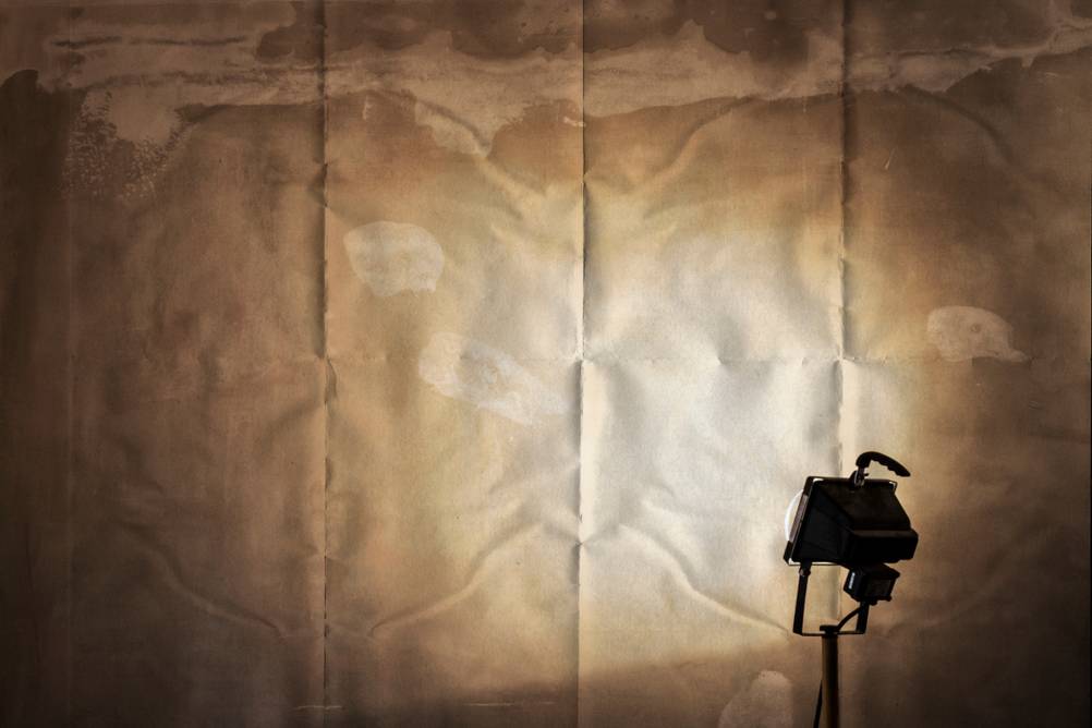 LED-Baustrahler mit Stativ vor einer Wand in Betrieb.