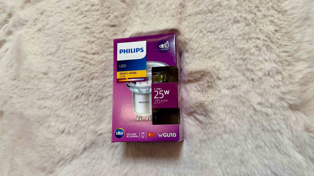Auf einem hellen Fell befindet sich eine getestete LED-GU10-Warmweiß in der Verpackung.