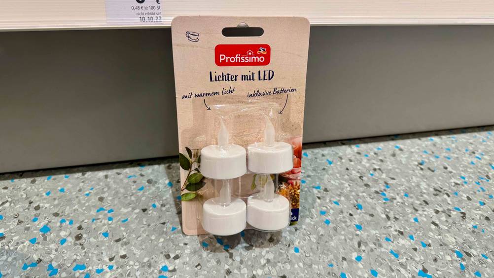 LED-Kerze getestet: Eine Packung lehnt an einem Regalbrett.