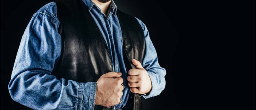 Lederwesten-Test: Mann in schwarzer Lederweste über blauem Hemd.