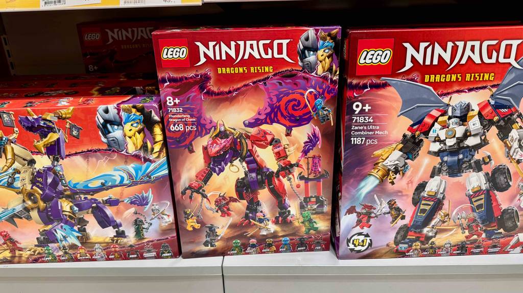 Mehrere verschiedene Lego-Ninjago-Figuren stehen zum testen verpackt in einem Regal.