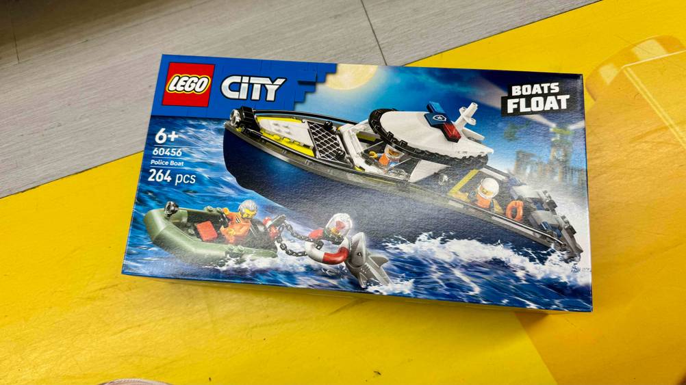 Auf einem gelben Boden liegt das originalverpackte Lego-Schiff im Test.