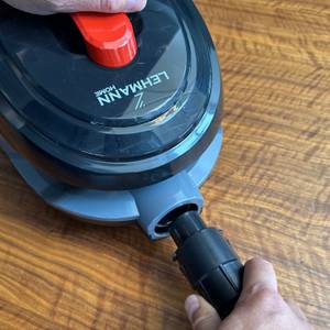 Eine Hand steckt den Schlauch an den Lehmann Typhoon