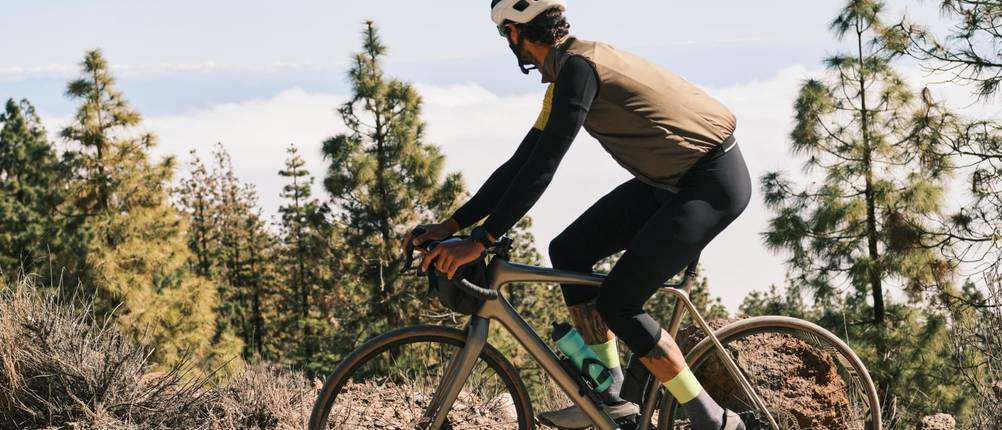 Fahrradweste-Herren-Test: Mann auf einem Mountainbike mit Fahrradweste auf einer Tour in den Bergen