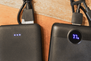 Test von leichten Powerbanks: Zwei getestete Powerbanks mit unterschiedlichen Ladestandsanzeigen liegen auf einem Tisch.