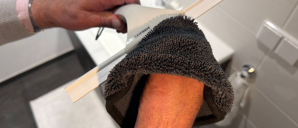 Eine Hand reinigt den Leifheit 41650 mit einem Lappen