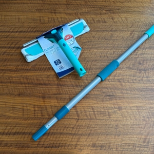 Der Abzieher und Wischer des Leifheit 55238 liegen eingepackt neben dem Griff auf einem Tisch