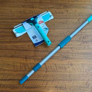 Der Abzieher und Wischer des Leifheit 55238 liegen eingepackt neben dem Griff auf einem Tisch