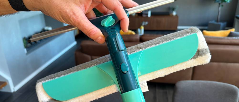 Eine Hand zieht den Abzieher aus der Halterung im Wischer des Leifheit 55238