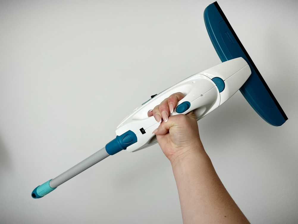 Der Leifheit-Dry-&-Clean-Fenstersauger ist mit einer Teleskopverlängerung ausgestattet. Die Hand hält das Gerät in Arbeitsposition.