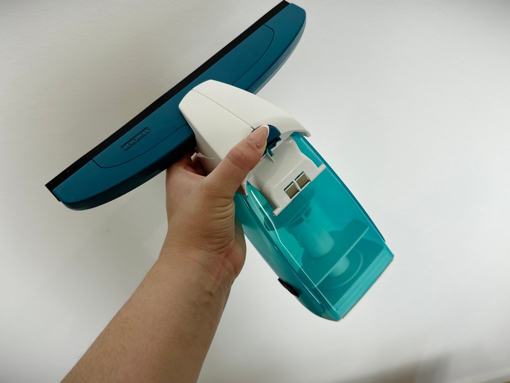 Der Leifheit-Dry-&-Clean-Fenstersauger wird von der Unterseite gezeigt. Der Tank mit türkisfarbenem Gehäuse ist vollständig sichtbar.