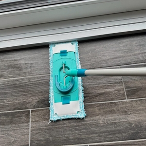 Der Bodenwischer des Leifheit Set Clean Twist M beim Reinigen einer Kante.