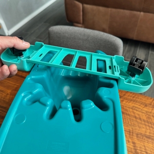 Eine Hand befestigt die Rollen am Eimer des Leifheit Set Clean Twist M.