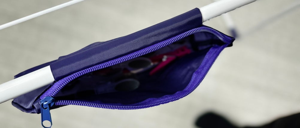 Der Stoffbeutel für Wäscheklammern ist mit einem Reißverschluss am Gestell des Leifheit-Standtrockners 81510 befestigt. Im Inneren sind Klammern und Zubehör sichtbar.