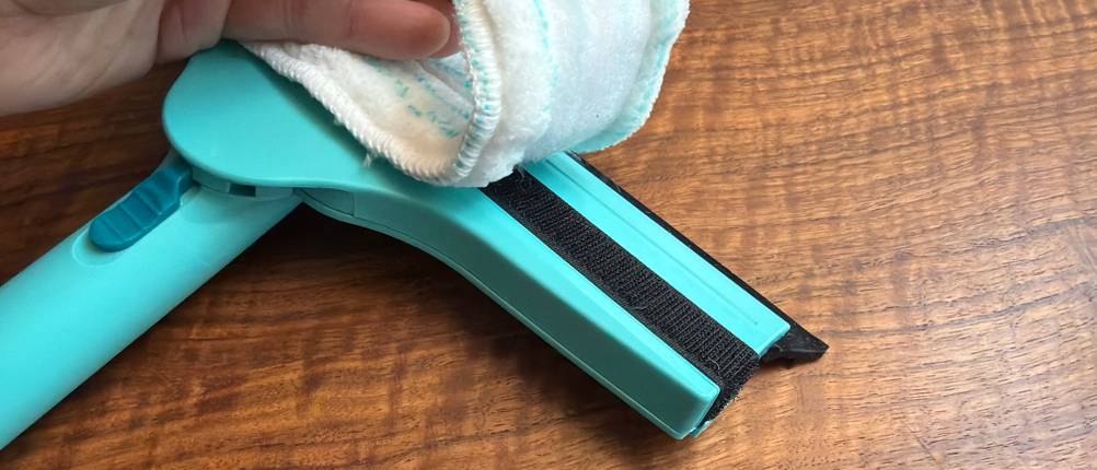 Eine Hand entfernt den Lappen vom Wischer vom Leifheit Window und Frame Cleaner L51120