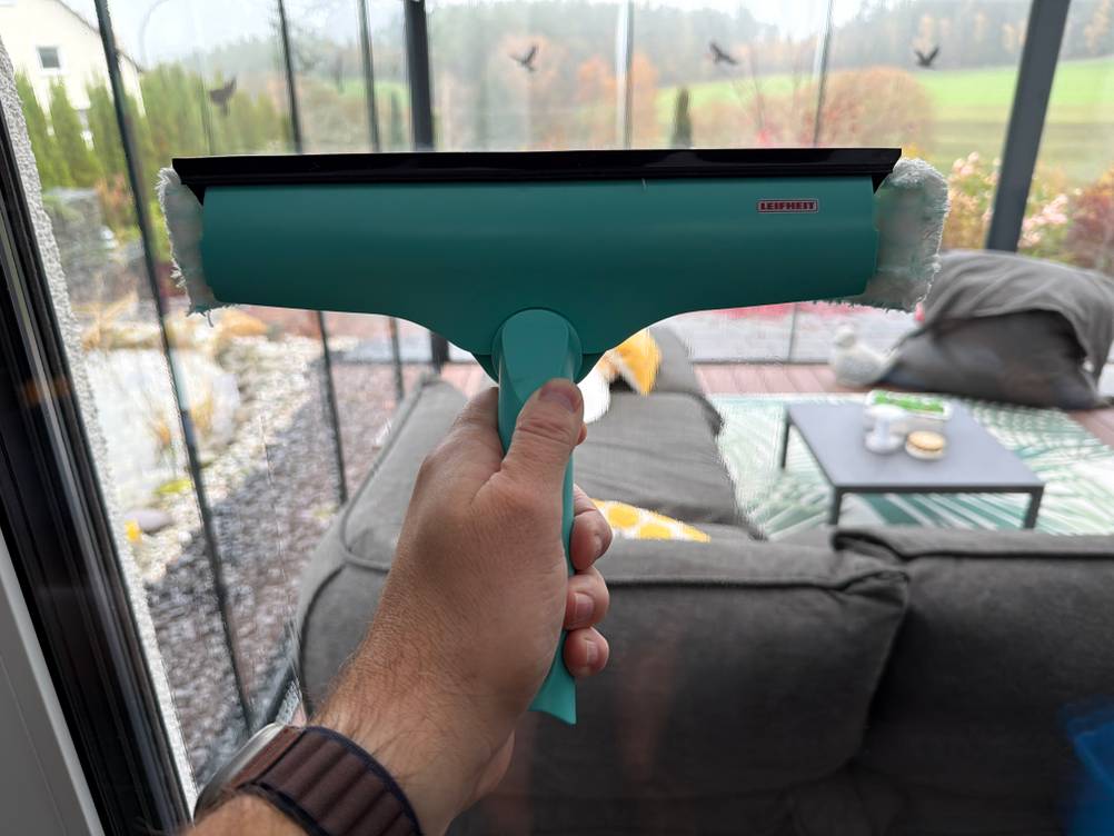 Mit dem Wischer vom Leifheit Window und Frame Cleaner L51120 wird ein Fenster gewischt