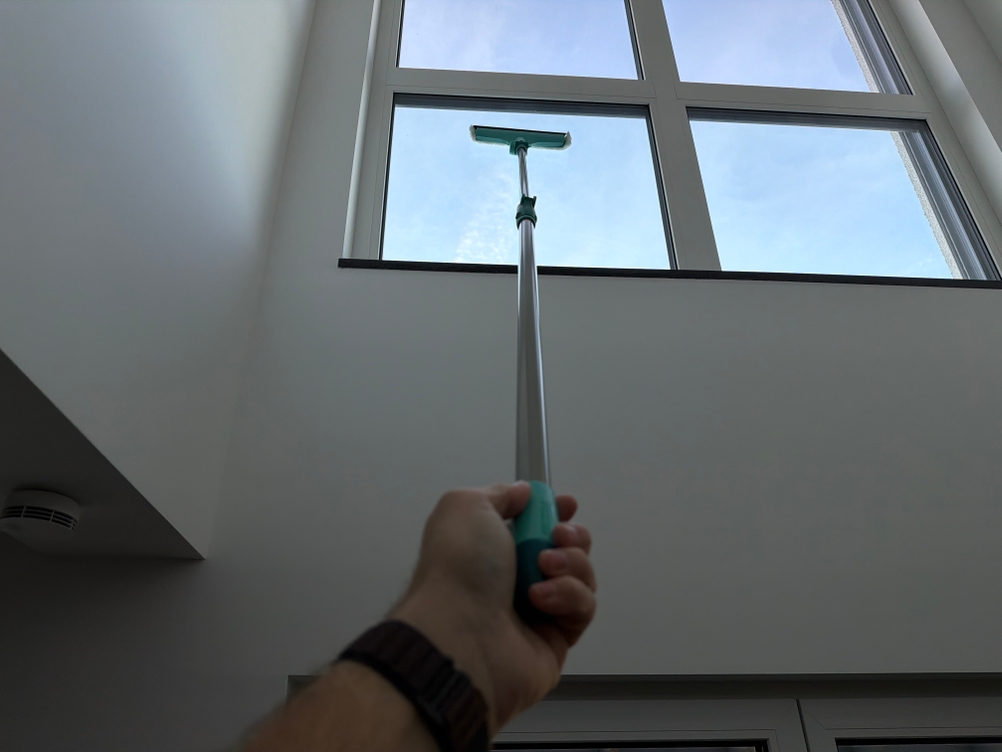 Mit dem Leifheit Window und Frame Cleaner L51120 wird ein hohes Fenster gewischt