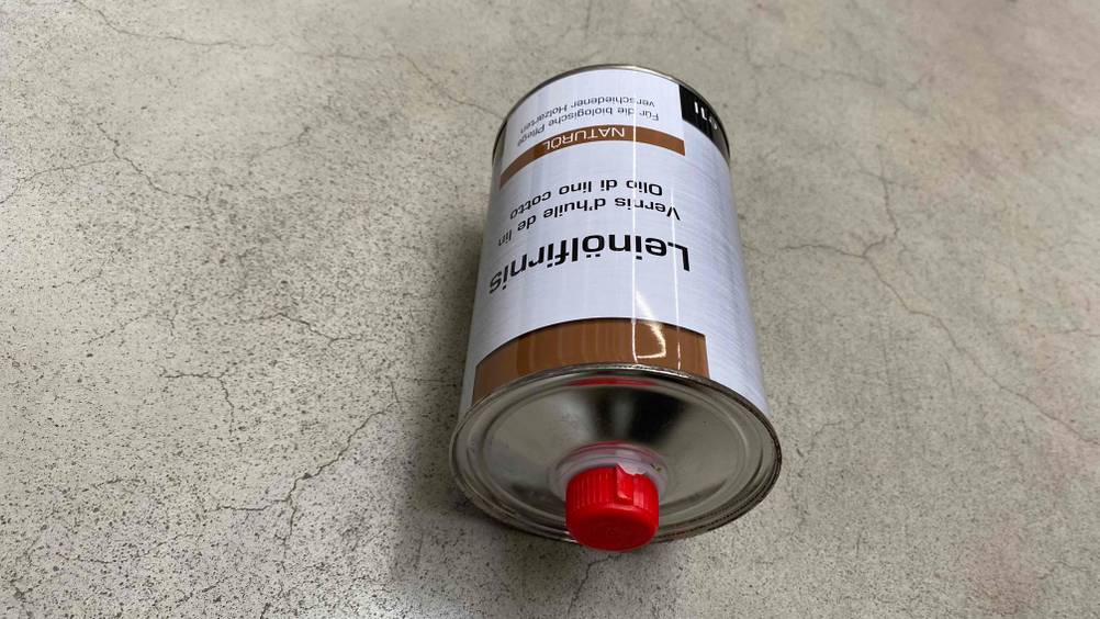 Getestetes Leinoelfirnis befindet sich in einer Flasche auf dem Boden.