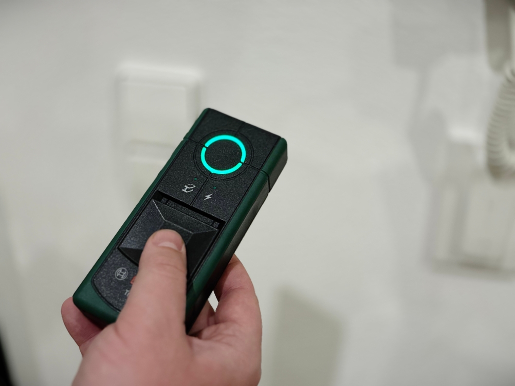 Eine Hand hält den ausgeschalteten Leitungssucher von Bosch.