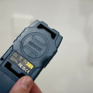 Eine Hand hält den Leitungssucher von Hanmatek.