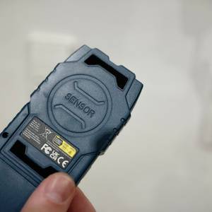 Eine Hand hält den Leitungssucher von Hanmatek.