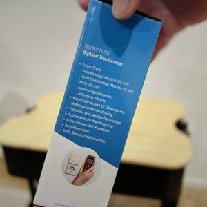 Eine Hand hält die Bedienungsanleitung.