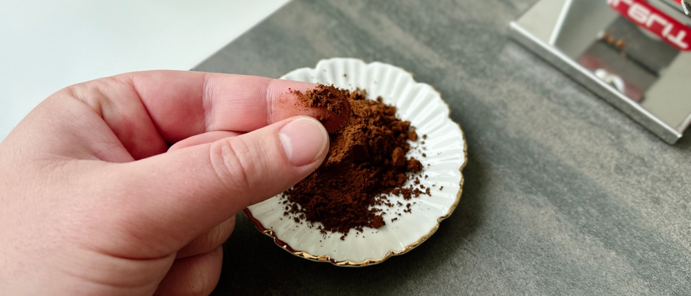 Espressomühlen im Test: Fein gemahlenes Espressopulver wird zwischen Fingern verrieben.