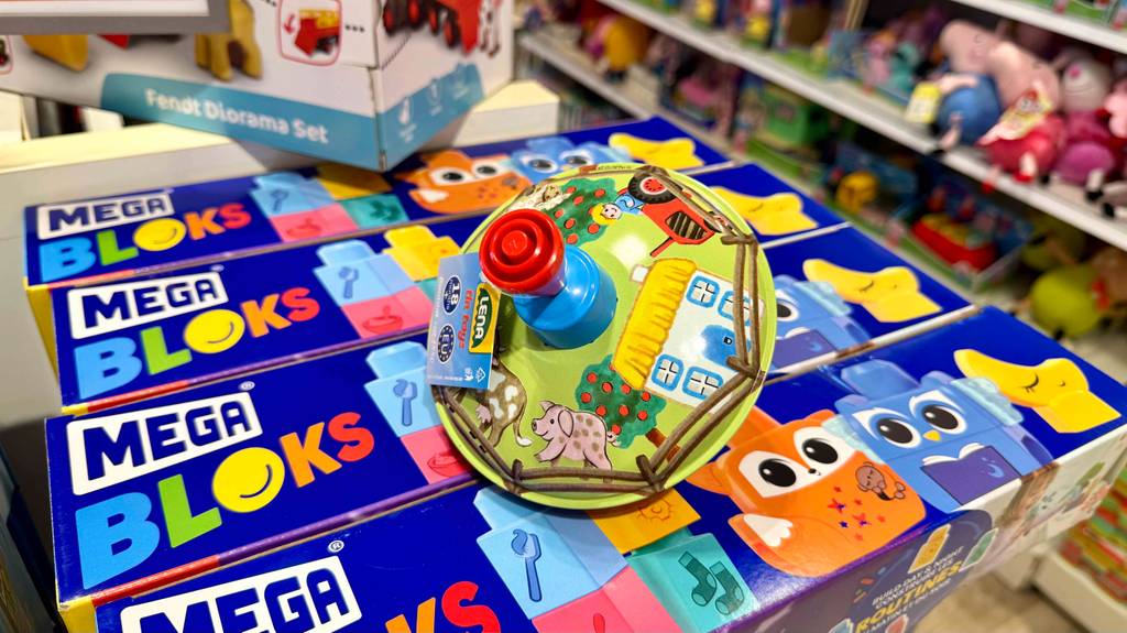 Blick von oben auf einen Brummkreisel, der zum testen auf mehreren Spielkartons liegt.