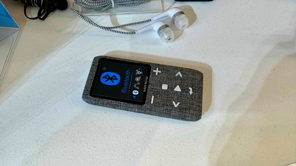 Im Test: Ein Bluetooth-MP3-Player liegt mit Innenkopfhörern auf einer weißen Fläche.
