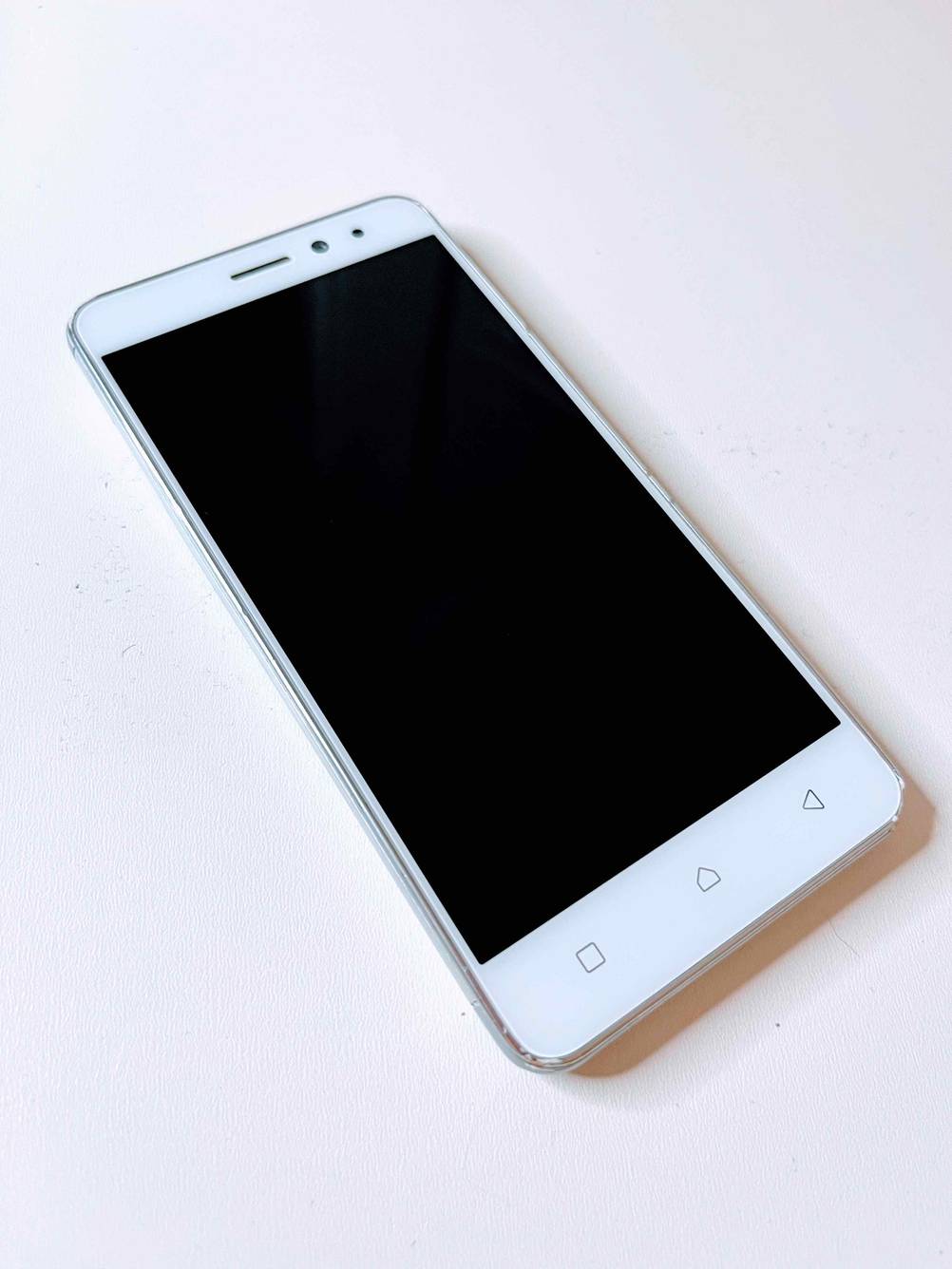Mittelklasse-Handy im Test: Ein Lenovo Handy liegt schräg auf weißer Fläche.