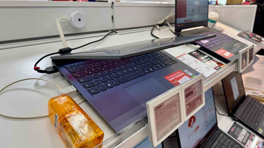 Im Test: Das Gaming-Laptop bis 800 Euro steht leicht aufgeklappt auf einem Ausstellungstisch neben weiteren Laptops.