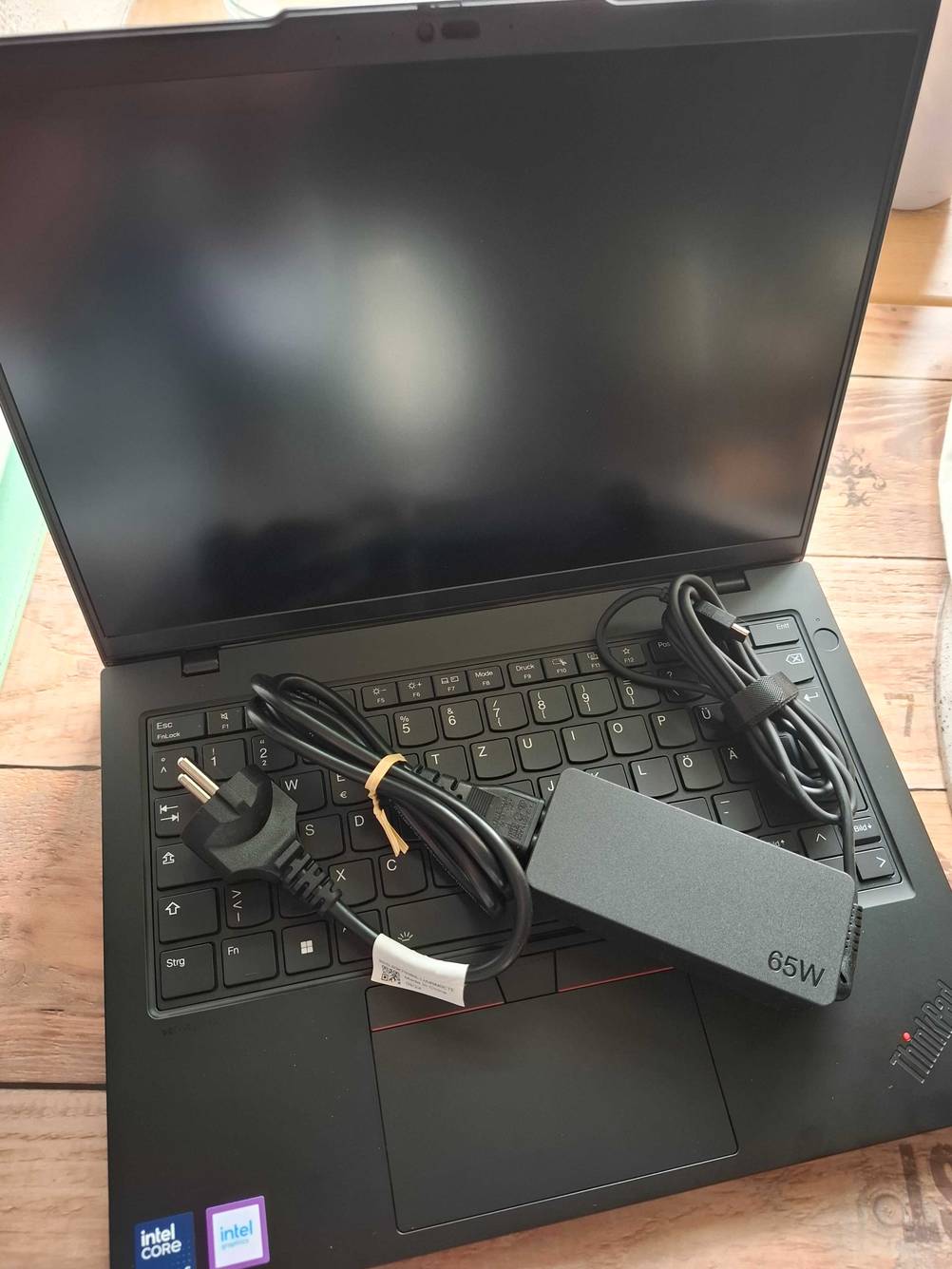 Das Netzteil mit Kabel liegt auf einem aufgeklappten getesteten Lenovo-Laptop 14 Zoll.