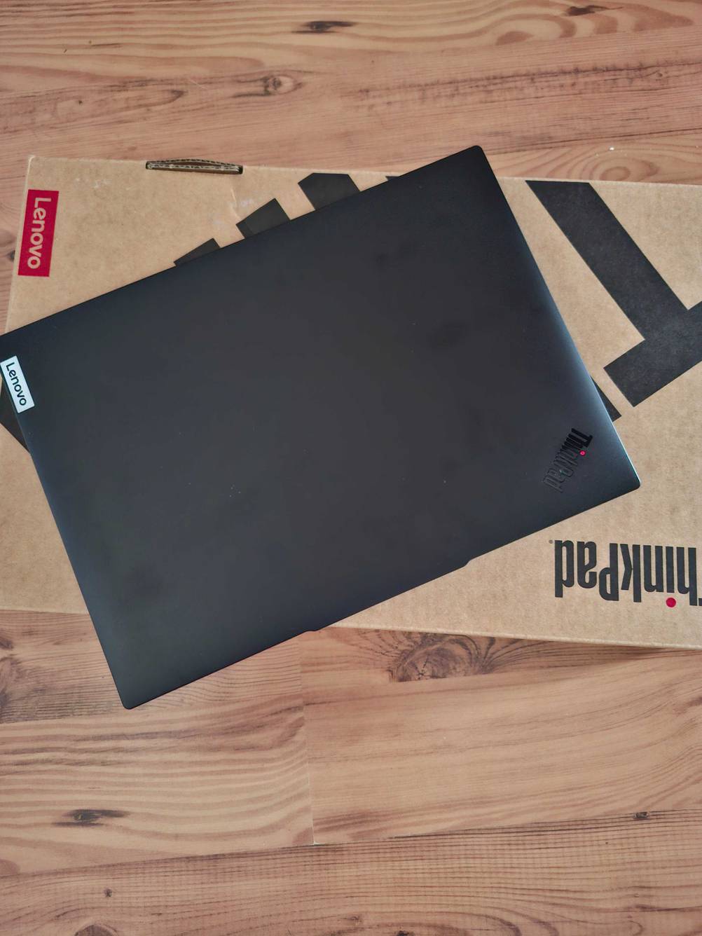 Ein zugeklapptes Lenovo-Laptop 14 Zoll liegt zum testen auf der Originalverpackung.