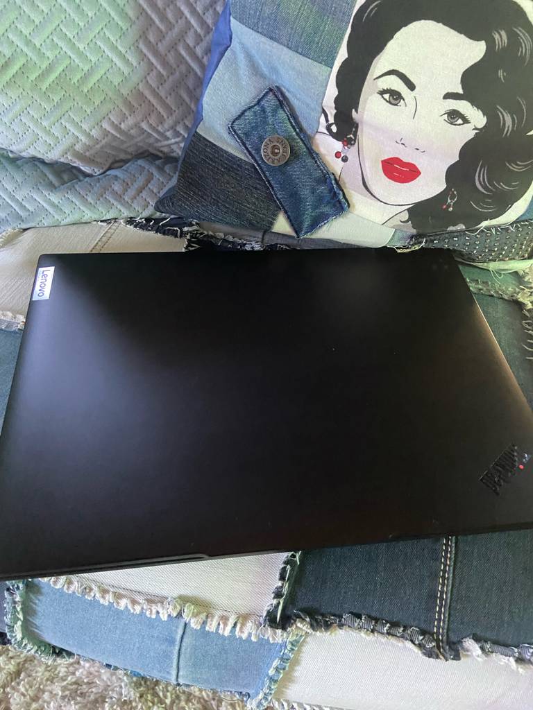 Ein zugeklapptes Lenovo-Thinkpad liegt getestet auf einer Jeanscouch.