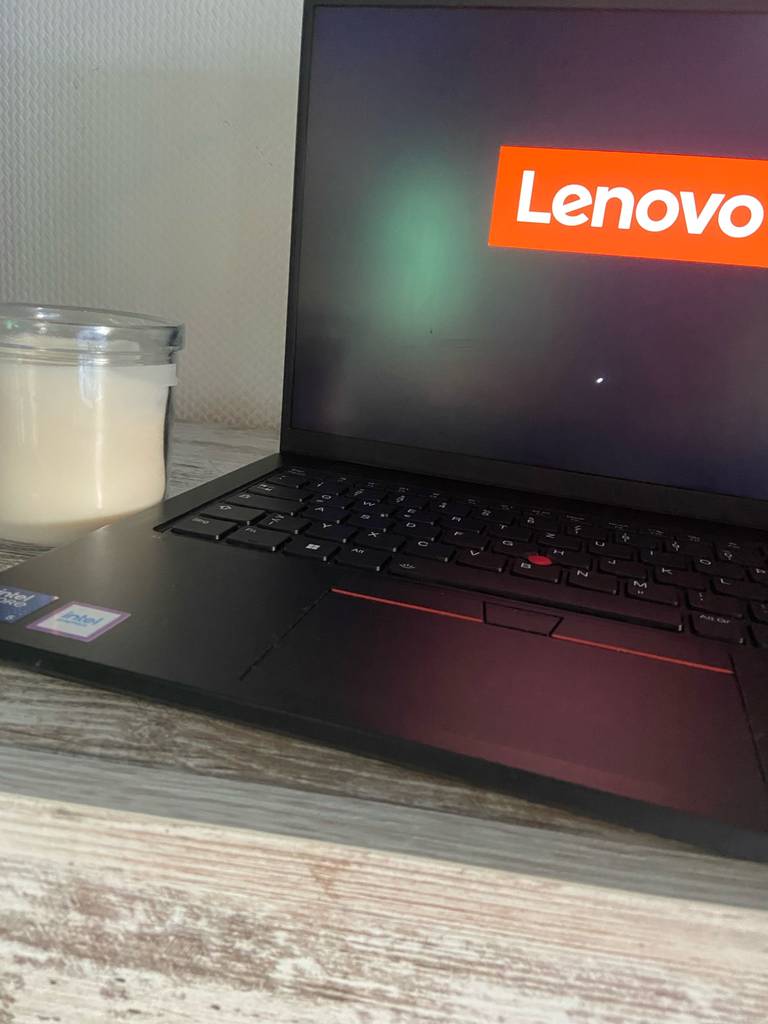 Im Test: Ein Lenovo-Thinkpad steht aufgeklappt neben einer Kerze im Glas.