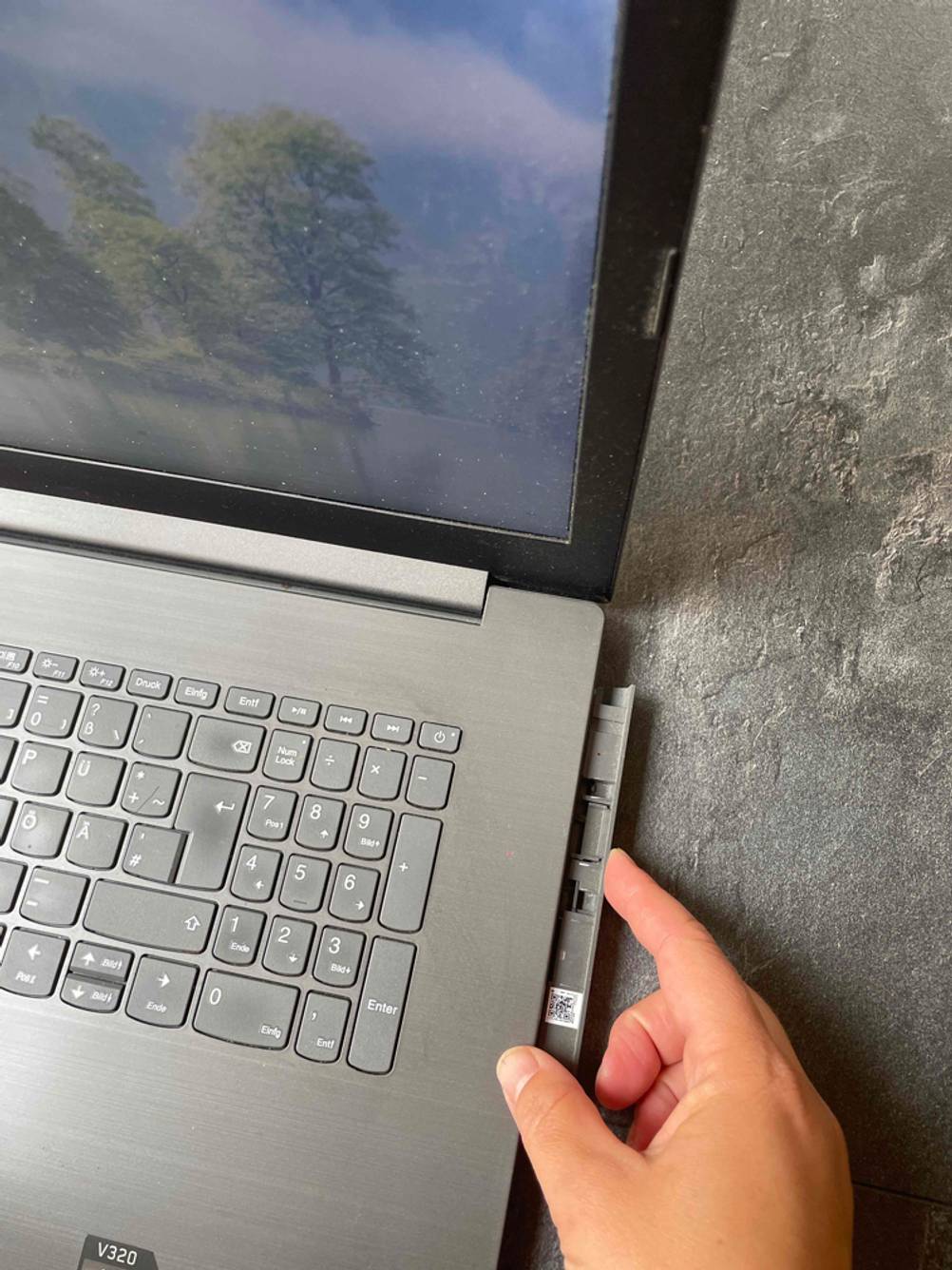 Laptop mit DVD-Laufwerk im Test: Eine Hand öffnet das DVD-Fach.